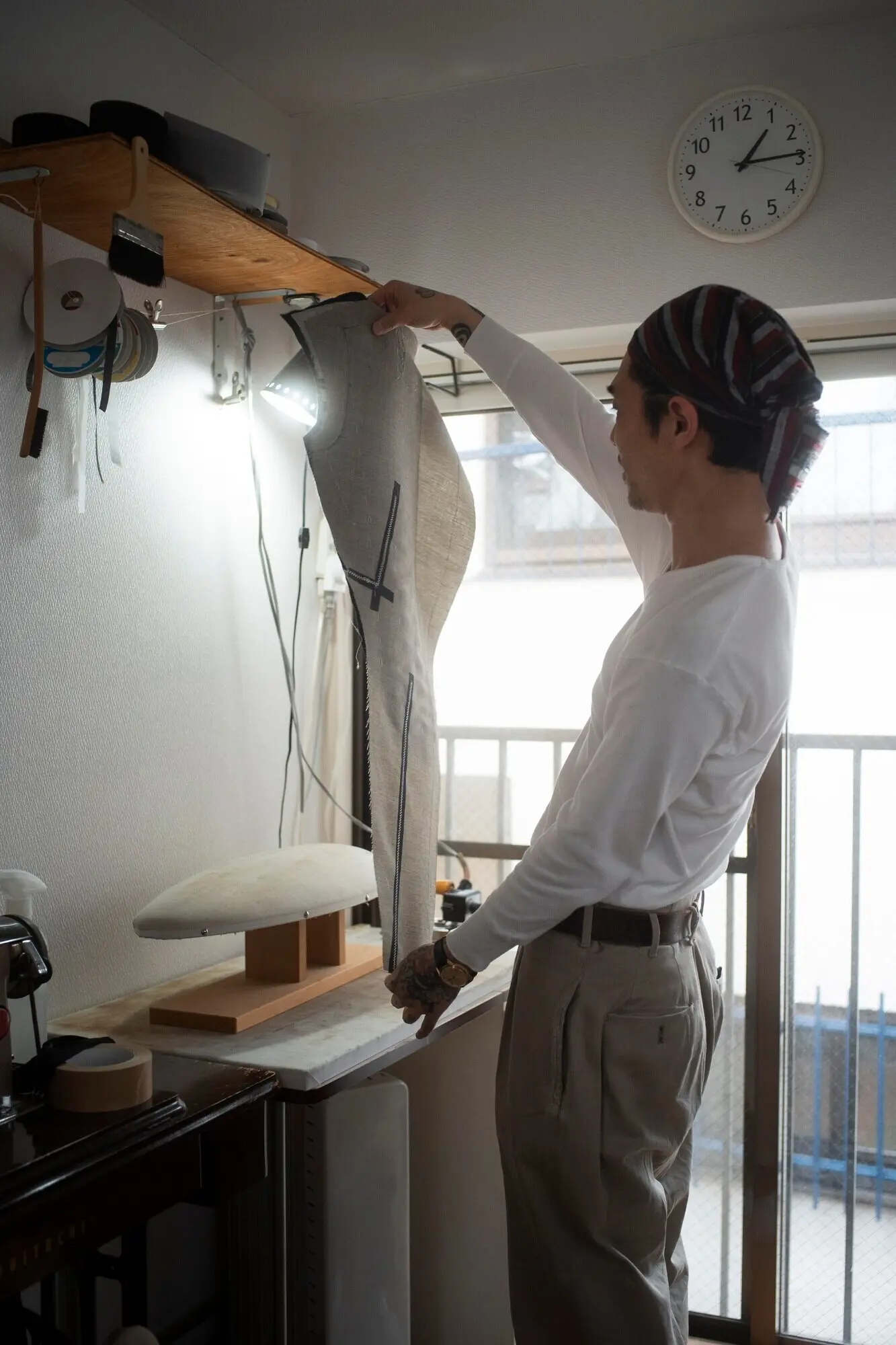 Снято средним планом: мужчина изготавливает одежду.